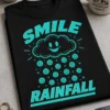 Majica z napisom SMILE RAINFALL, nasmejanim oblačkom in dežjem smeškov