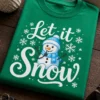 Majica z napisom Let it Snow, snežakom, modro kapo in šalom ter snežinkami