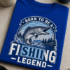 Majica z napisom BORN TO BE A FISHING LEGEND in retro ribiškim emblemom z ribo
