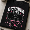 Majica z napisom OCTOBER GIRL in stiliziranim ženskim motivom z rožnatimi očali