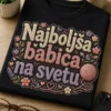 Majica za babico z napisom Najboljša babica na svetu, pletenim učinkom črk, prejo in nežnimi rožicami v toplih pastelnih barvah.