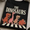 Majica z napisom THE DINOSAURS in dinozavri, ki hodijo čez prehod v retro parodičnem slogu
